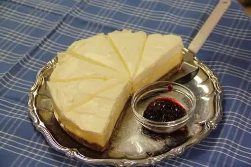 Kaffestugan i Alphems Arboretum: Cheesecake med hallonsås Cheesecake med hallonsås serverad på en silverbricka, perfekt för en fika på Kaffestugan i Alphems Arboretum.