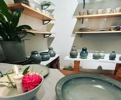 Interiörbild av Ellinors Keramiks butik med vackra keramikföremål på hyllor och bord.