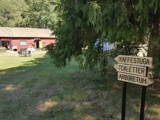 Kaffestugan i Alphems Arboretum: Mysig Vägskylt Välkomnande skyltar leder dig till Kaffestugan i Alphems Arboretum, ett paradis för fika och avkoppling.