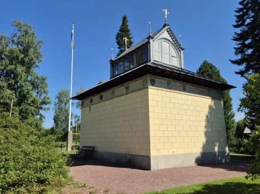 Baksidan av monumentet med torn Vasamonumentets baksida med fönsterförsett torn, dekorationer i järnsmide och en svensk flagga i bakgrunden.