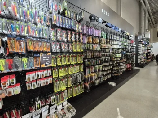 Astro Sweden - Fiskeavdelningen En lång vägg fylld med fiskedrag, linor och utrustning i Astro Swedens fiskeavdelning.