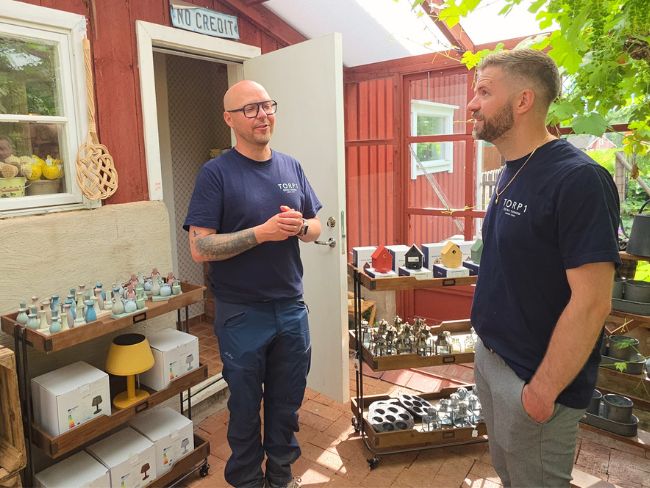 Fredrik och Emil på Torp1 Fredrik och Emil utanför Torp1 i Östra Tunhem, omgivna av presentartiklar, inredningsdetaljer och produkter i den mysiga butiken.